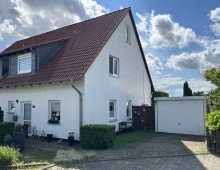 Seitlicher Blick von der Stra�e auf den Giebel und Garage Doppelhaush�lfte in Gr. Fl�the - Feldrandlage - vermietet, gepflegt und mit Entwicklungsperspektive